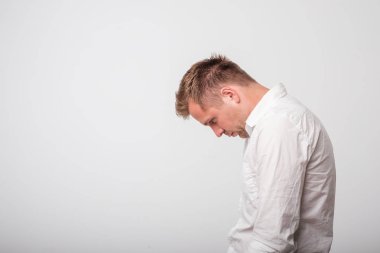 üzgün Avrupa beyaz genç adam beyaz gömlek aşağı bakıyor