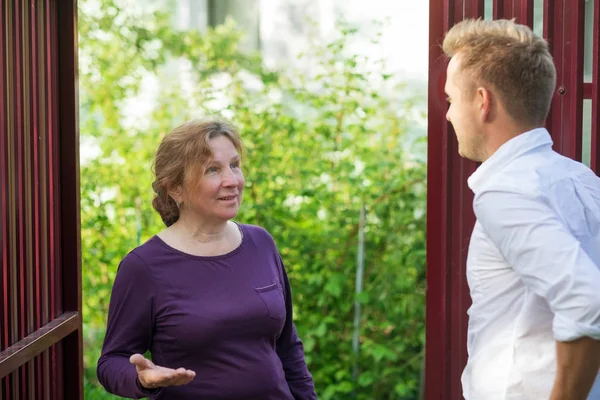Neighbors Discuss News Standing Fence Elderly Woman Talking Young Man — Stock Photo, Image