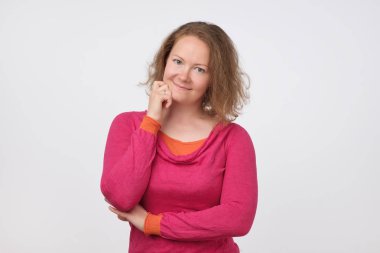 Gülümseyen Avrupa kadın sıcak kazaklı kameraya bakıyor. gri arka plan üzerinde izole. Kendinden emin ve bağımsız olması