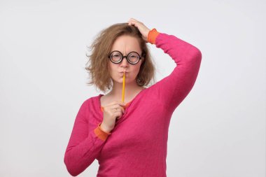 Akıllı fikirli kadın komik gözlük ağız yakınındaki kalem tutan mükemmel fikir düşünüyorum. Komik öğretmen sınav ve ders planı hakkında düşünme.