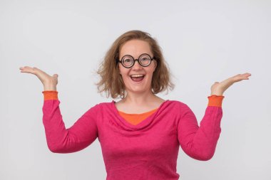 Pembe polo ve komik daire gözlük kadar el ile poz mutlu güzel kadın. Geek erkek satış veya iş yerinde ilerleme ile şaşırır