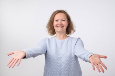 Hoş geldiniz ya da kavram sevindim. Avrupa kadın gergin eller ile mavi kazaklı. O arkadaşları sarılmak istiyor. İfade duygu ve duyguları kavramı.