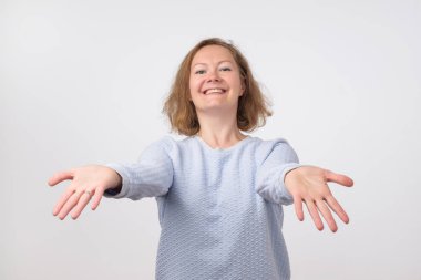 Hoş geldiniz ya da kavram sevindim. Avrupa kadın gergin eller ile mavi kazaklı. O arkadaşları sarılmak istiyor. İfade duygu ve duyguları kavramı.