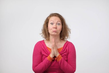 Lütfen beni affet. Yalvaran, avuç içi birlikte basarak, kederli yüz ifadesi, sahip sinir bozucu üzgün orta yaşlı Avrupa kadın bağışlanmak için yalvarıyor erkek.