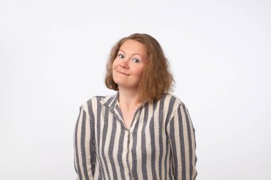 Kameraya bakarak çizgili gömlekli Avrupa kadın gülümsüyor, gri arka plan üzerinde izole.