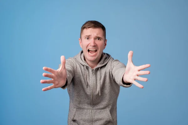 Studio portrait of european man pulling his hands ahead. — Stock Photo, Image