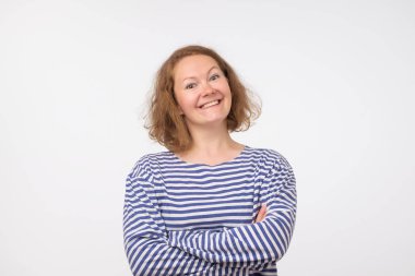 Deniz pulover kameraya bakarak Avrupa kadın gülümsüyor, gri arka plan üzerinde izole.