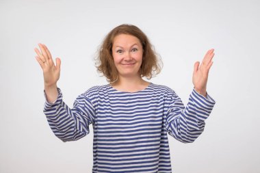 Çizgili gömlekli elleriyle boyut olarak büyük bir şey gösterilen komik kadın.