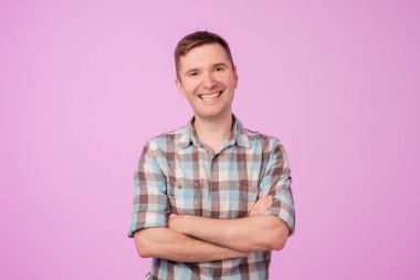 Kendine güvenen genç yakışıklı adam geçti ve mavi beyaz arka plan karşı dururken gülümseyen silah tutmak