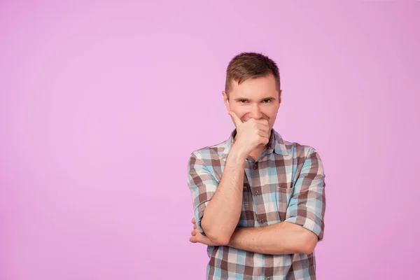 Prise de vue d'un jeune homme caucasien attrayant regardant la caméra avec une expression drôle rusée, fermant sa bouche — Photo