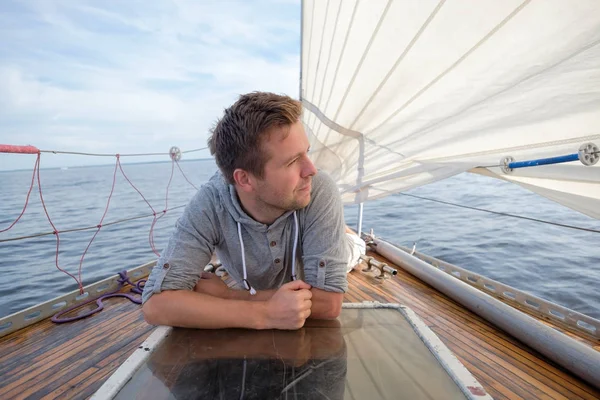 Joven europeo sentado en un yate mirando el mar . — Foto de Stock