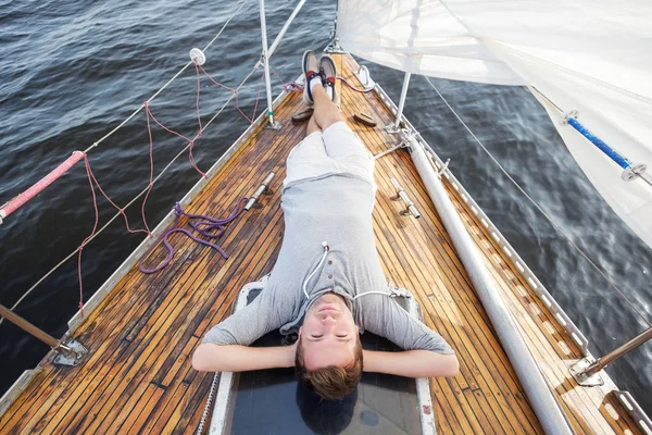 Joven europeo sentado en un yate mirando el mar . — Foto de Stock