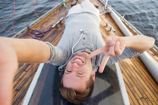 Young european man making selphie on yacht. — Stock Photo, Image