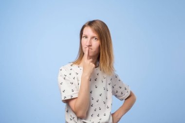 Genç dalgın kafkas kadın şüphe ile mavi arka plan üzerinde seyir