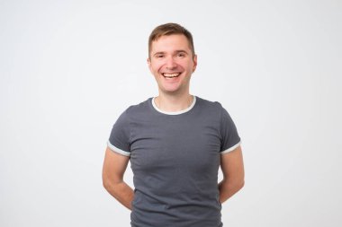 Beyaz arka plan karşı dururken gülümseyen kendine güvenen genç yakışıklı adam. Olumlu yüz duygu