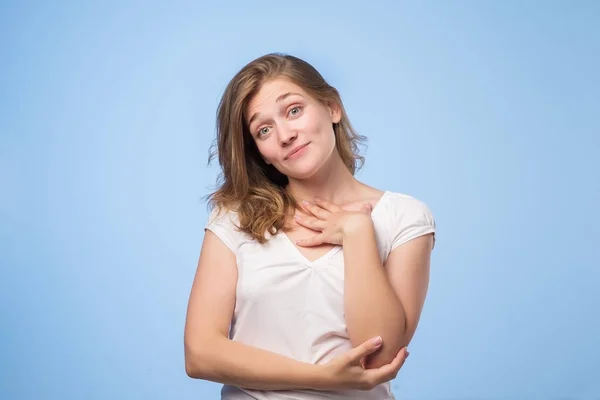 Mujer caucásica agradable vistiendo top blanco sonriendo ampliamente y manteniendo la mano en su mejilla, feliz de recibir elogios —  Fotos de Stock