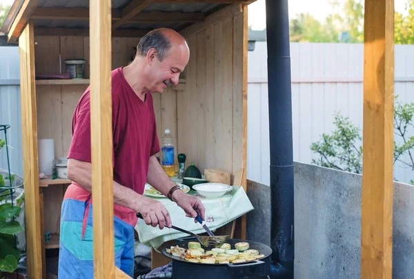 Man koken een courgette in de achtertuin. — Stockfoto