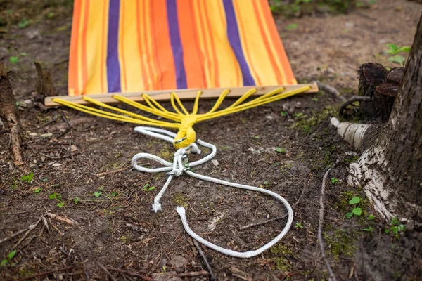 An orange broken hammock on ground