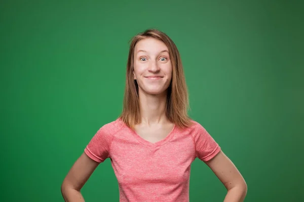 Retrato de menina caucasiana animado em t-shirt rosa no fundo de cor verde . — Fotografia de Stock