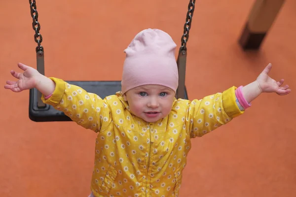 Pretty female infant after swinging stretches her hand. — Stock Photo, Image