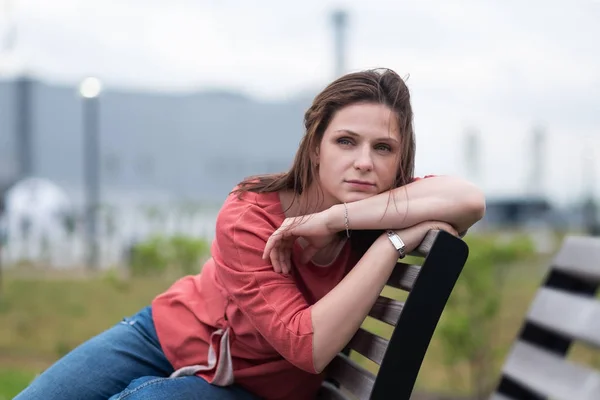 Europeiska kvinna sitter tyvärr i park och tittar åt sidan — Stockfoto