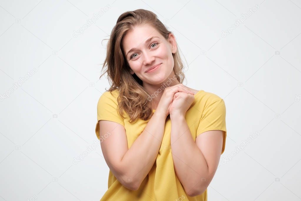 Pleased caucasian woman smiling broadly, glad to receive compliments from friends, standing on white background