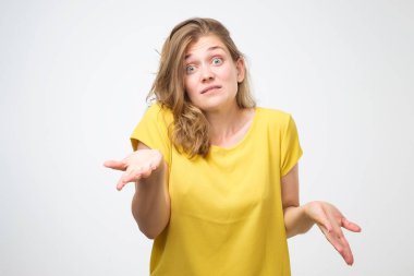 Önemli bir şey değil. Sarı tişört shrugging içinde clueless genç kadın omuzlar ve kamera şaşkın bakışla o sonra bakan bir şey yanlış yaptım