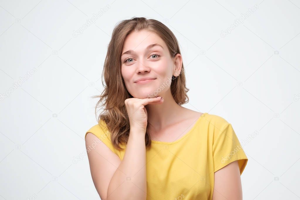 Indoor close up shot of young attractive european woman, smiling warmly and friendly while listening to you