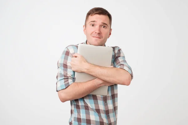 Retrato de laptop jovem confiante em pé contra a parede azul — Fotografia de Stock