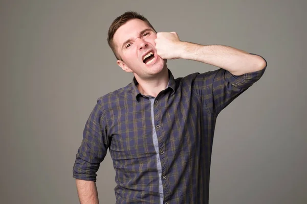 Hombre europeo golpeándose con el puño en la cara . — Foto de Stock