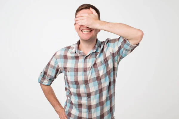 Portrait d'un jeune homme souriant couvrant ses yeux de sa main — Photo