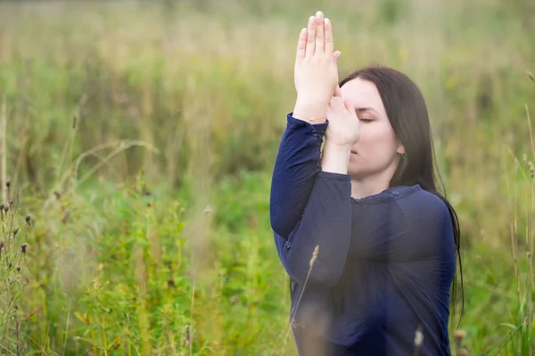 Seitenansicht einer Frau, die mit verschränkten Armen Yoga-Übungen durchführt. Adler-Pose. — Stockfoto