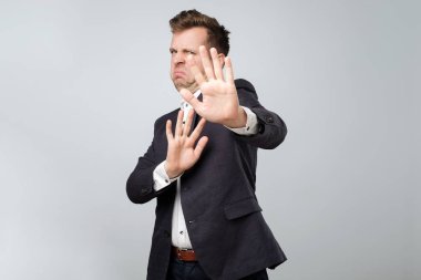 Dur işaretini gösteren mavi elbiseli mutsuz casual adam portresi. İlişkileri devam etmek için inkar. Benden uzak gitmek.