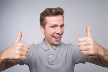 Başparmak gösterilmesini mutlu yakışıklı adam. Stüdyo çekimi kapat