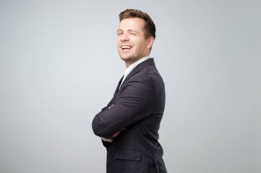 Göz göz kırpıyor genç iyimser beyaz iş adamı. Stüdyo çekimi