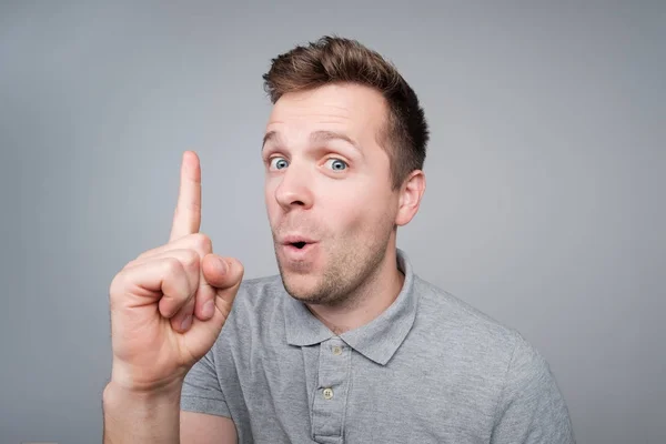 Young european handsome man showing index finger up. He has wonderful idea. — Stock Photo, Image