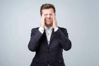 Yakışıklı genç adam kafasını el duygu güçlü baş ağrısı ile dokunmak.