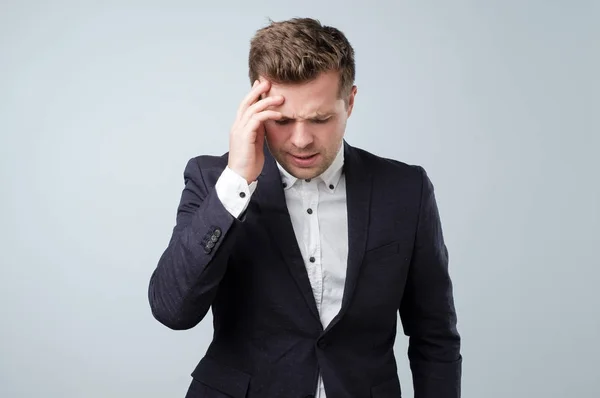 Joven guapo tocándose la cabeza con la mano sintiendo fuerte dolor de cabeza . —  Fotos de Stock