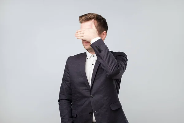 Caucásico hombre de traje cubriendo sus ojos — Foto de Stock