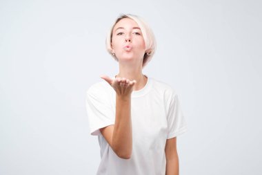 mükemmel renkli saç modeli ile çekici sevimli güzel kadın. Erkek arkadaşına bir hava öpücük gönderiyor