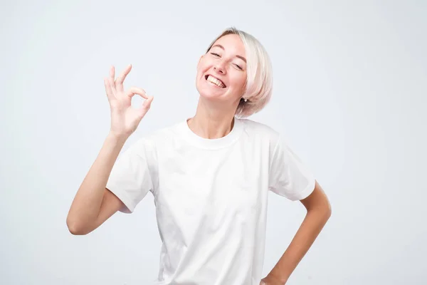 Mulher adulta jovem atraente com cabelo curto colorido mostrando sinal ok . — Fotografia de Stock