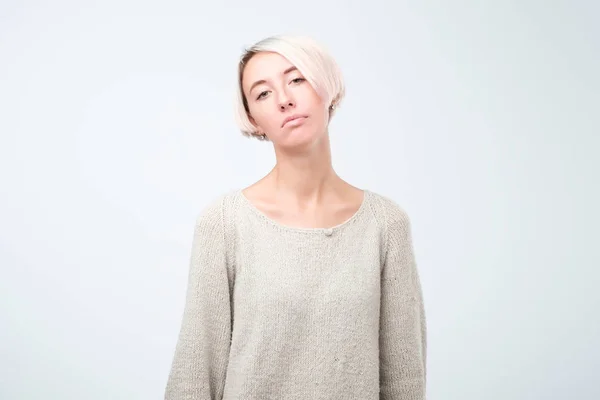 Ernstige Europese vrouw met grijze trui tegoed met gekruiste armen — Stockfoto
