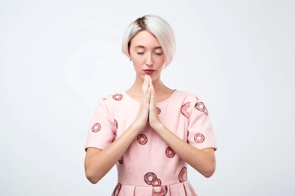 Jonge lachende vrouw met korte geverfd haarstijl mediteren, vasthouden van haar handen in yoga gebaar, rustig gevoel — Stockfoto