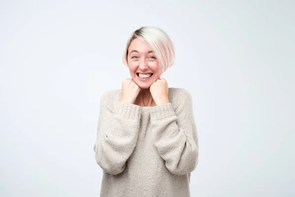 Молода біла жінка посміхається стоячи на сірому фоні — стокове фото