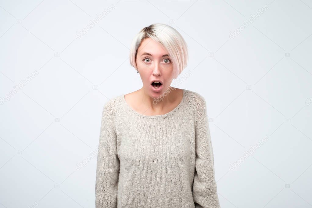 Beautiful surprised woman standing with open mouth. Human emotions, facial expression concept.