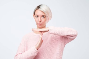 Zaman aşımı jest, beyaz arka plan üzerinde izole gösterilen boyalı kısa saçlı güzel genç kadın