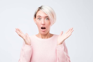 Üzerinde gri studio backgroud izole güzel kadın varoluş açık portre. Pembe kazak ayakta ile duygusal sürpriz kadında genç açık ağız