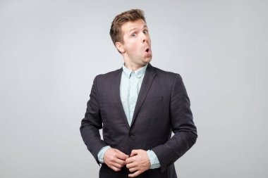 Genç hayran adam portresi uygun izole üzerinde gri arka plan