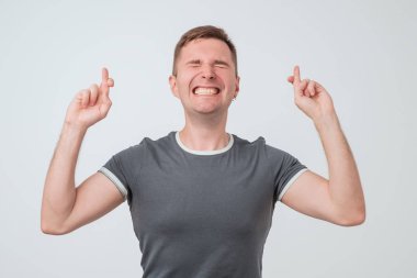 Genç adam bir dilek işaret parmaklarını beyaz arka plan üzerinde izole geçiş yapma