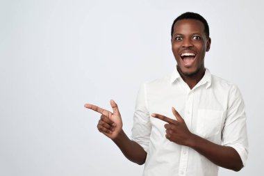 Uzağa işaret ve gülümseyerek kameraya bakıyor Afrika yakışıklı genç